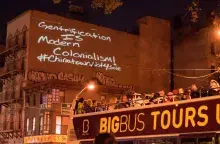 A CAB projection installation reading "Gentrification is Modern Colonialism!" 